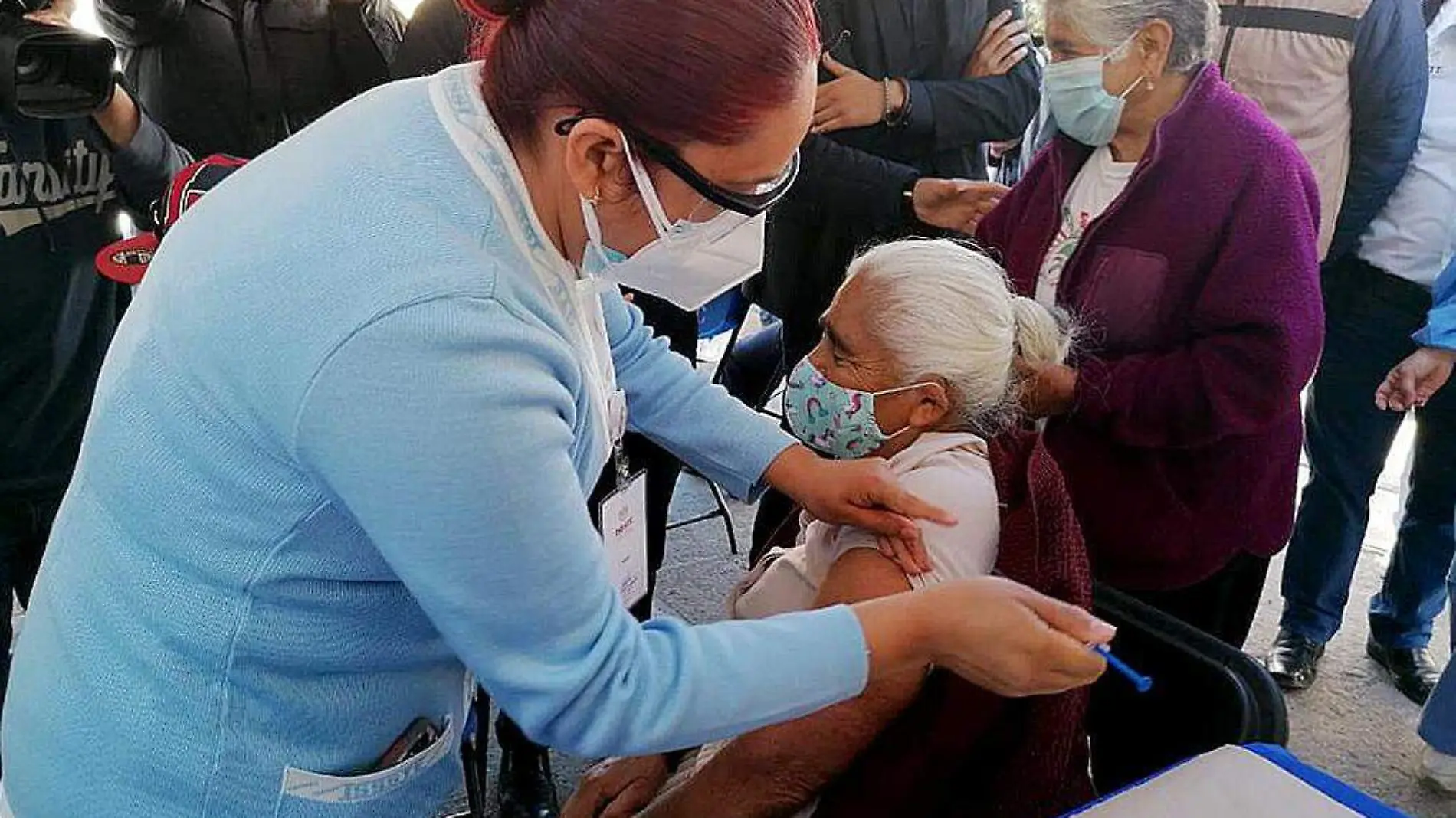 Enfermera aplicando vacuna a persona mayor